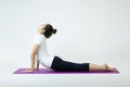 Young sporty woman practicing yoga, working out, wearing sportswear, pants and top, indoor full length, white  studio. Royalty Free Stock Photo