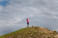 Young sporty woman in sportswear on hill top making selfie with smartphone on cloudy sky background. Fitness, healthy way of life Royalty Free Stock Photo