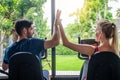 Young sporty woman and man giving each other a high five after cycling training in gym. Fit couple high five after workout in Royalty Free Stock Photo