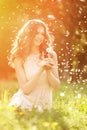 Young spring fashion woman blowing dandelion in spring garden. S Royalty Free Stock Photo