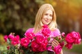 Young spring fashion woman with roses in spring garden. Springtime. Trendy girl at sunset in spring landscape background. Royalty Free Stock Photo