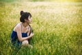 Young spring fashion woman sitting on the grass field Royalty Free Stock Photo