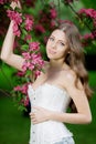 Young spring fashion woman in spring garden Springtime Summertime Trendy girl in the flowering trees in then at sunset in spring Royalty Free Stock Photo