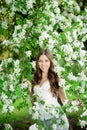 Young spring fashion woman in spring garden Springtime Summertime Trendy girl in the flowering trees in then at sunset in spring Royalty Free Stock Photo