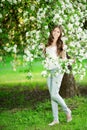 Young spring fashion woman in spring garden Springtime Summertime Trendy girl in the flowering trees in then at sunset in spring Royalty Free Stock Photo