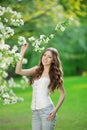 Young spring fashion woman in spring garden Springtime Summertime Trendy girl in the flowering trees in the spring summer garden Royalty Free Stock Photo