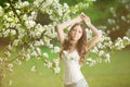 Young spring fashion woman in spring garden Springtime Summertime Trendy girl in the flowering trees in the spring summer garden Royalty Free Stock Photo