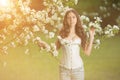 Young spring fashion woman in spring garden Springtime Summertime Trendy girl in the flowering trees in the spring summer garden Royalty Free Stock Photo