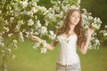 Young spring fashion woman in spring garden Springtime Summertime Trendy girl in the flowering trees in the spring summer garden Royalty Free Stock Photo