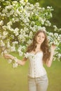 Young spring fashion woman in spring garden Springtime Summertime Trendy girl in the flowering trees in the spring summer garden Royalty Free Stock Photo