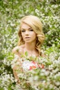 Young spring fashion woman. Trendy girl in the flowering trees i Royalty Free Stock Photo