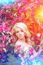 Young spring fashion woman. Trendy girl in the flowering trees i Royalty Free Stock Photo