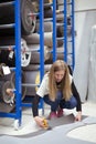 Young squatting woman cutting a piece of carpet in an upholstery store