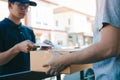 Young staff delivery man of the parcel carrier is submitting the documents to the customers to receive at home