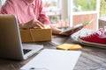 start up small business owner checking product order at workplace. freelance woman entrepreneur SME seller prepare parcel box for Royalty Free Stock Photo