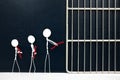 Young stick man figure handcuffed tied with red rope going to a jail prison in dark background. Lowering age for criminal.