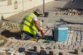 A young stone mason laying cobbles in Albuferia Portugal