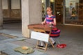 Young street musician girl sits on the street and plays for tour Royalty Free Stock Photo