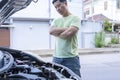 Young stressed Asian man having trouble with his broken car Royalty Free Stock Photo