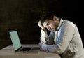 Young stressed businessman working on desk with computer laptop in frustration and depression Royalty Free Stock Photo