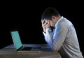 Young stressed businessman working on desk with computer laptop in frustration and depression Royalty Free Stock Photo