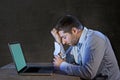 Young stressed businessman working on desk with computer laptop in frustration and depression Royalty Free Stock Photo