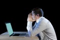 Young stressed businessman working on desk with computer laptop in frustration and depression Royalty Free Stock Photo