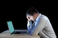 Young stressed businessman working on desk with computer laptop in frustration and depression Royalty Free Stock Photo