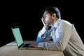 Young stressed businessman working on desk with computer laptop in frustration and depression Royalty Free Stock Photo