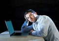 Young stressed businessman working on desk with computer laptop in frustration and depression Royalty Free Stock Photo