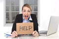 Young stressed businesswoman holding help sign overworked at office computer Royalty Free Stock Photo