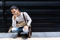 Young stressed and depressed businessman squat down outside office building waiting for job interview results. Working man feeling Royalty Free Stock Photo