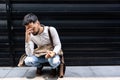 Young stressed and depressed businessman squat down outside office building waiting for job interview results. Working man feeling Royalty Free Stock Photo