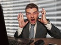 Young stressed and overwhelmed businessman in suit and necktie desperate working at office laptop computer desk screaming crazy Royalty Free Stock Photo