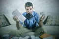 Young stressed and overwhelmed man biting calculator holding mess of bank and receipts paperwork desperate calculating monthly exp Royalty Free Stock Photo