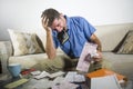 Young stressed and overwhelmed man biting calculator holding mess of bank and receipts paperwork desperate calculating monthly exp Royalty Free Stock Photo