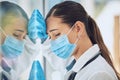 Young stressed and overworked doctor wearing mask and gloves while standing at a window in a hospital or clinic. One Royalty Free Stock Photo