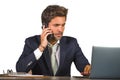 Young stressed and upset business man working at office computer desk talking frustrated on mobile phone feeling tired Royalty Free Stock Photo