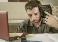 Young stressed and worried man at home living room using calculator and laptop doing domestic accounting paperwork feeling Royalty Free Stock Photo