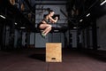 Young strong sweaty fit muscular girl with big muscles doing box jump hardcore cross workout training in the gym Royalty Free Stock Photo