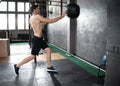 Young strong fit muscular man doing throwing medicine ball up on the wall for crossfit training hard core workout in gym Royalty Free Stock Photo