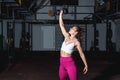 Young strong fit muscular sweaty girl with big muscles strength cross workout training with dumbbells weights in the gym dark imag Royalty Free Stock Photo