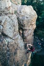 Young slender climber climbs a rock Royalty Free Stock Photo