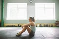 Young and strong girl with a smile doing exercises for the muscles of the stomach, press on the floor in the spore Royalty Free Stock Photo