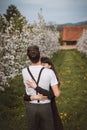 Young strong love between two young people standing under apple trees. Candid portrait of a couple in casual clothes. Affection of Royalty Free Stock Photo