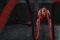 Young strong man doing battle ropes exercise at the crossfit gym Royalty Free Stock Photo