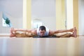 A young strong man doing yoga exercises -Samakonasana Straight angle pose in the yoga studio Royalty Free Stock Photo
