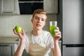 Young strong man having light breakfast.Apple juice in the kitchen. Fresh fruits and healthy food Royalty Free Stock Photo