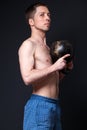 Young strong man in shorts holding a dumbbell with both hands. Royalty Free Stock Photo