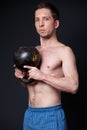 Young strong man in shorts holding a kettlebell with both hands Royalty Free Stock Photo